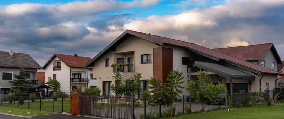 Einfamilienhaus mit Garten und Zaun in einer Wohnsiedlung