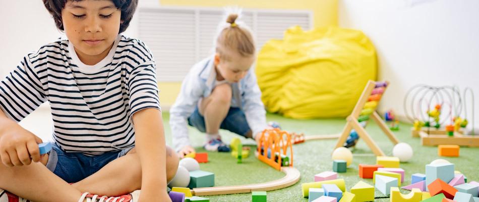 Kinder spielen mit Bausteinen in einem hellen Gruppenraum einer Kindertagesstätte